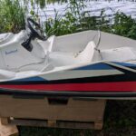 Ein weißes Gliss-Speed Elektroboot aufgebockt am Ufer in Potsdam zur Reparatur wegen Wassereintritts.